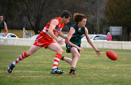 Sam Bioletti and the Swans' William Priest chasing after the ball.